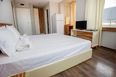 a bedroom with a large white bed and a television at JBH Hotel in Sveti Vlas