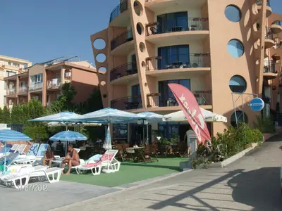a group of chairs and umbrellas in front of a building at Hotel Evridika in Nesebar