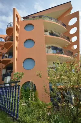an orange building with round windows and a fence at Hotel Evridika in Nesebar