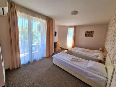 a hotel room with two beds and a large window at Hotel Mida in Obzor