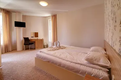 a bedroom with a bed and a desk in it at Hotel Mida in Obzor