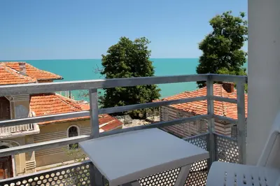 a balcony with a bench and a view of a building at Hotel Mida in Obzor