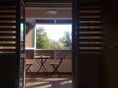 a room with a balcony with a table and chairs at Odessus in Varna City