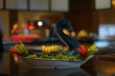 a statue of a swan on a bowl of flowers at Wave Resort - Ultra All Inclusive in Pomorie