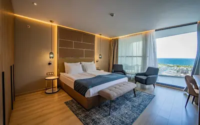 a hotel room with a bed and a large window at Wave Resort - Ultra All Inclusive in Pomorie