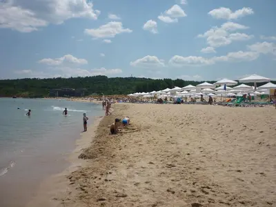 a group of people on a beach with umbrellas at Ganozliev's Apartments in Kavatsi Area in Sozopol