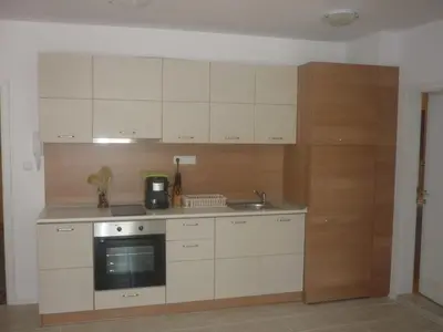 a kitchen with white cabinets and a sink at Ganozliev's Apartments in Kavatsi Area in Sozopol