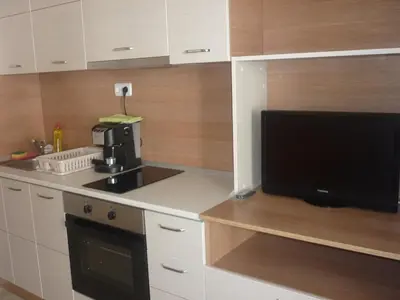 a kitchen with a flat screen tv and a microwave at Ganozliev's Apartments in Kavatsi Area in Sozopol