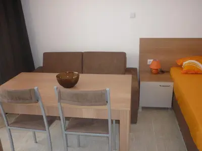 a dining room table with two chairs and a couch at Ganozliev's Apartments in Kavatsi Area in Sozopol