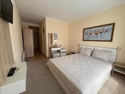 a hotel room with a bed and a television at Guest house Marina in Obzor