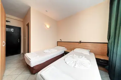 a hotel room with two beds and a window at Hotel Varly Bryag in Burgas City