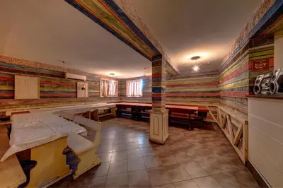 a room with colorful walls and tables and benches at Hotel Varly Bryag in Burgas City