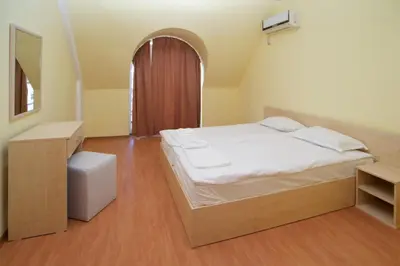 a bedroom with a large white bed and a table at Aparthotel Anixi in Obzor