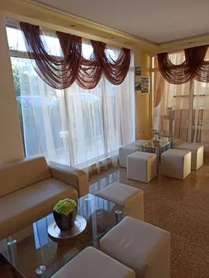 a living room with couches and tables and large windows at Aparthotel Anixi in Obzor