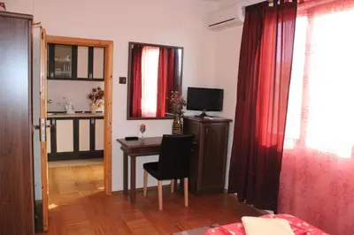 a living room with a table and a television at Guest House Dara in Tsarevo