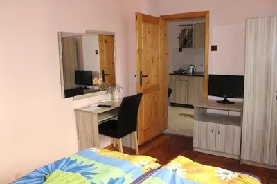 a bedroom with a bed and a desk with a computer at Guest House Dara in Tsarevo