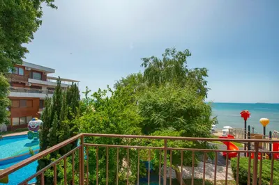 a balcony with a view of a pool and the ocean at Messambria Beach Apartments in Sveti Vlas
