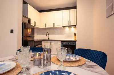 a kitchen with a table with plates and glasses on it at Messambria Beach Apartments in Sveti Vlas