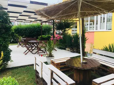 a wooden deck with a table and an umbrella at Hotel Elmaz in Lozenets