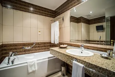 a bathroom with a tub and a sink at Hotel Palace Marina Dinevi in Sveti Vlas