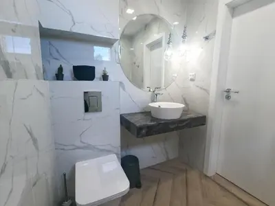 a white bathroom with a sink and a mirror at Dion Apartments in Lozenets