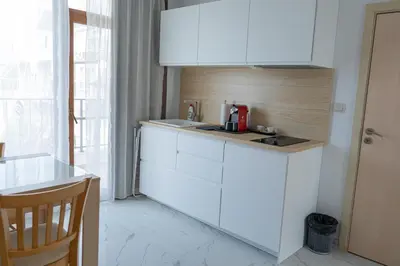 a kitchen with white cabinets and a counter top at Dion Apartments in Lozenets