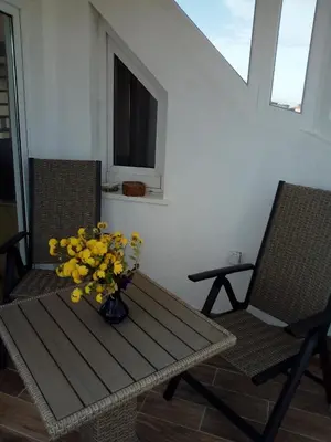 a table and two chairs with a vase of yellow flowers at Studio Lilou in Varna City