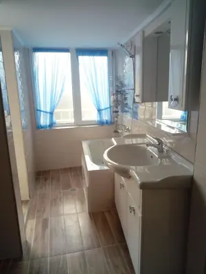 a bathroom with a sink and a large window at Studio Lilou in Varna City