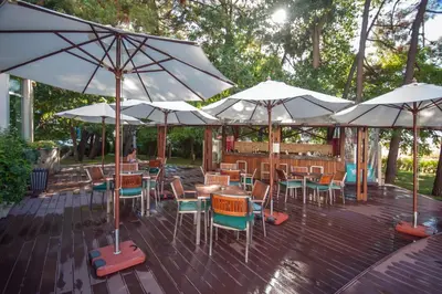 a patio with tables and chairs and umbrellas at Jeravi Beach Hotel - All Inclusive in Sunny Beach