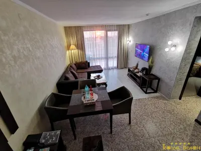 a living room with a couch and chairs and a television at ROYAL BEACH HOTEL apartment in Sunny Beach