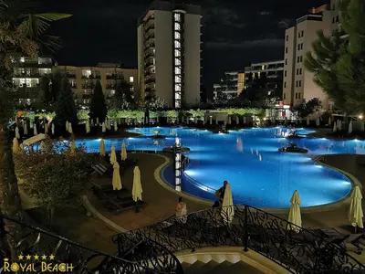 a large pool of blue water with umbrellas at ROYAL BEACH HOTEL apartment in Sunny Beach