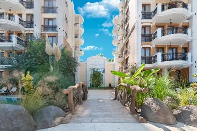 a walkway in front of two apartment buildings at Harmony Suites Grand Resort in Sunny Beach