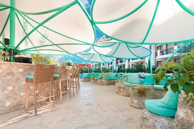 a patio with tables and chairs and umbrellas at Harmony Suites Grand Resort in Sunny Beach