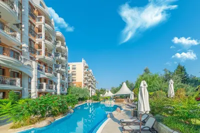a pool at a resort with chairs and umbrellas at Harmony Suites Grand Resort in Sunny Beach