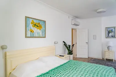 a bedroom with a bed and a painting on the wall at KApartments in Varna City