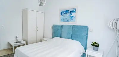 a bedroom with a white bed and a blue headboard at KApartments in Varna City