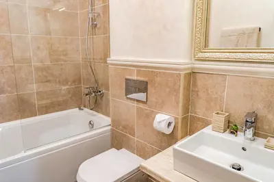 a bathroom with a tub and a toilet and a sink at KApartments in Varna City
