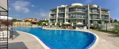 a hotel with a swimming pool in front of a building at Gardenia Suites in Sozopol