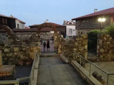 a couple of people walking through a stone wall at Gardenia Suites in Sozopol