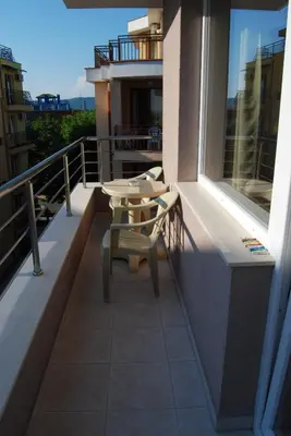 a balcony with a table and chairs on a building at Guest House Donchevi in Primorsko