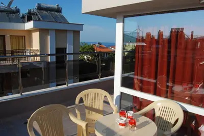 a table and chairs on a balcony with a view at Guest House Donchevi in Primorsko