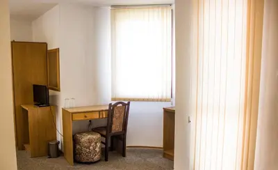 a room with a desk with a chair and a window at Family Hotel Saint Iliya in Burgas City