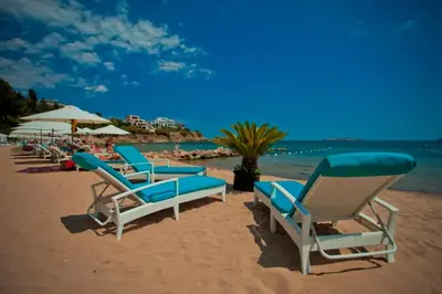 a group of chairs and umbrellas on a beach at July's Island Deluxe in Chernomorets