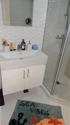 a bathroom with a white sink and a shower at July's Island Deluxe in Chernomorets