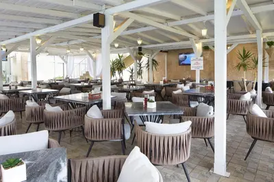 a restaurant with tables and chairs in a room at Apart Hotel Vechna R in Sunny Beach