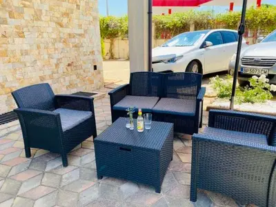 a patio with four chairs and a table with drinks on it at Апартхотел Созополски перли in Sozopol