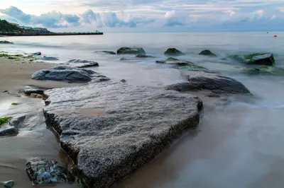 a beach with rocks in the sand and water at Garden of Eden Complex in Sveti Vlas
