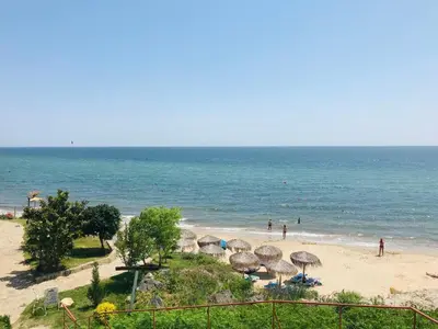 a beach with umbrellas and people on the beach at PS Apartment / SunCoast Resort in Sveti Vlas