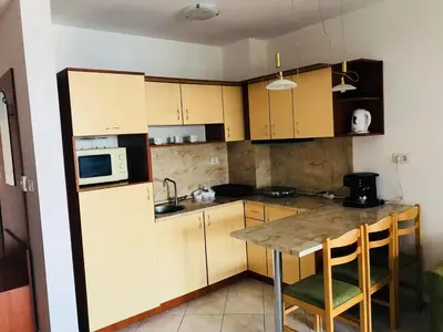 a small kitchen with a table and a microwave at PS Apartment / SunCoast Resort in Sveti Vlas