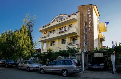 a building with cars parked in front of it at Guest House Gardeli in Tsarevo